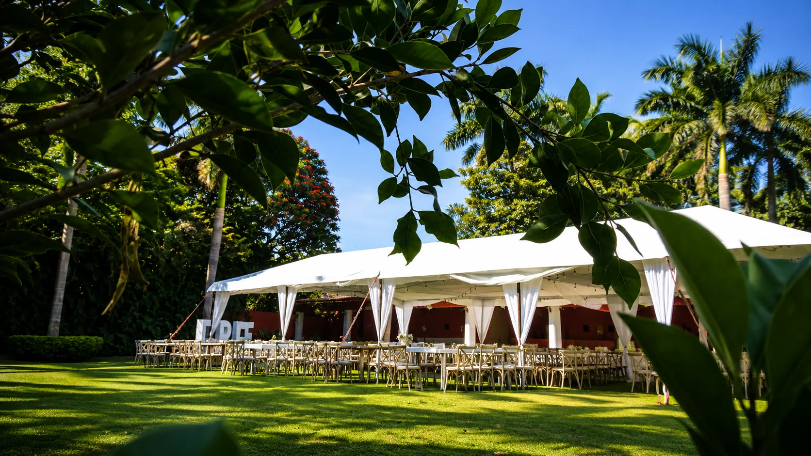 Carpa de evento montada en jardín rodeado de palmeras en Rancho Ixtla Las Palmas